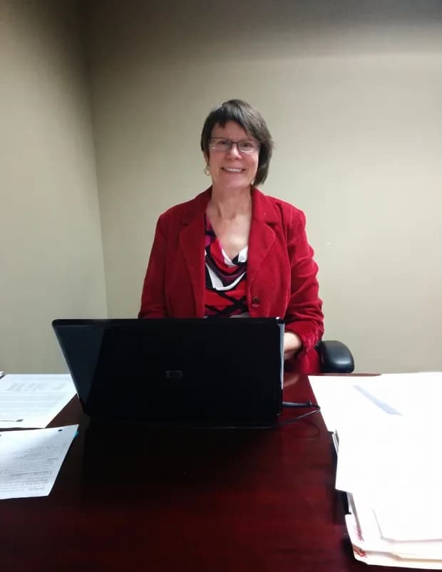 A nonprofit leader in a red sweater reviewing grant work